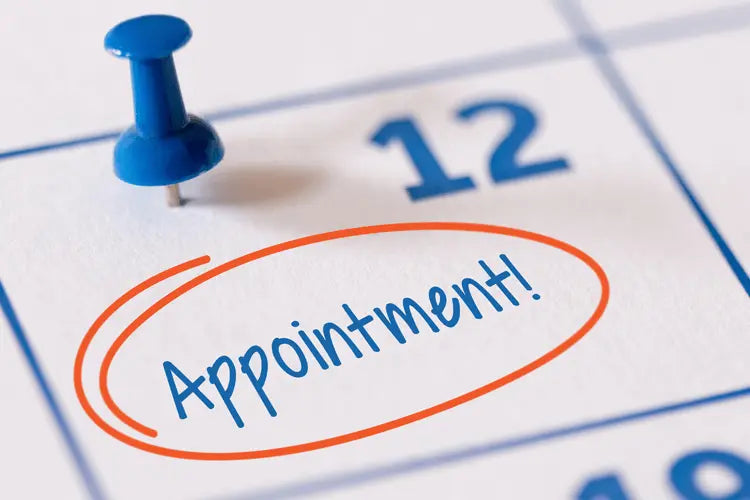 Calendar with 'Appointment!' written on a date, pinned with a blue thumbtack.
